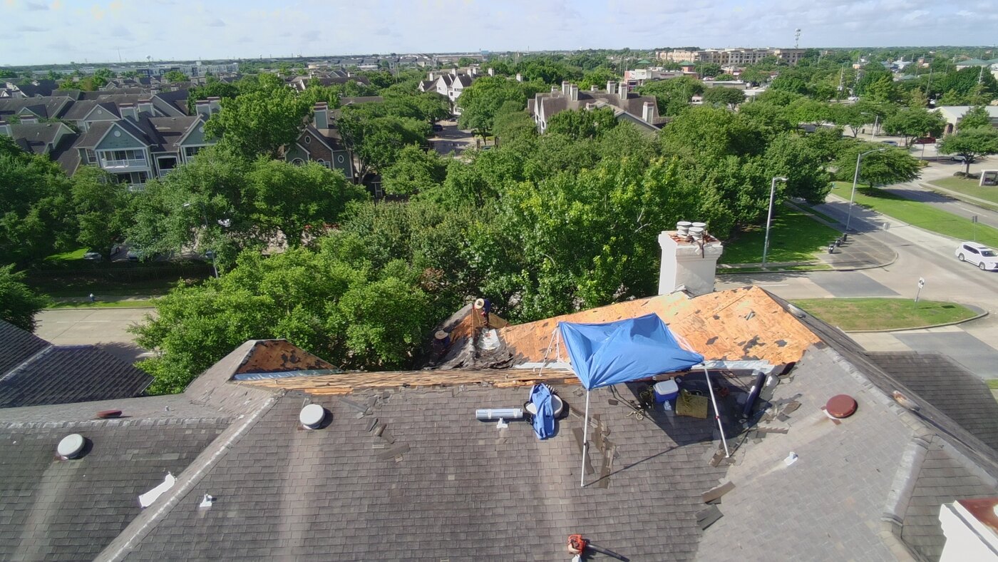Roofing crew installing shingles on an apartment building